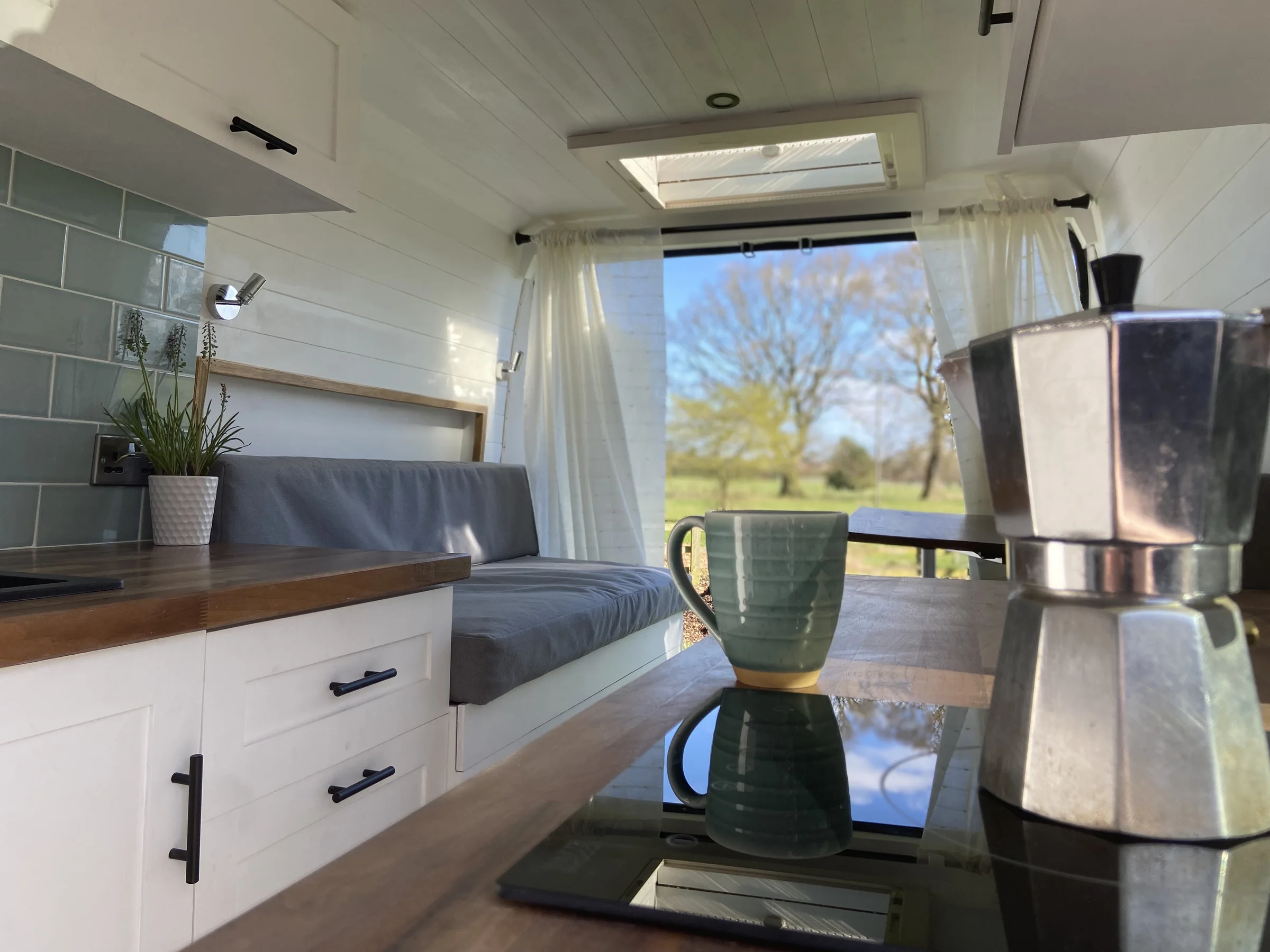Moka pot and coffee mug on the induction hob inside the Roam Wired campervan