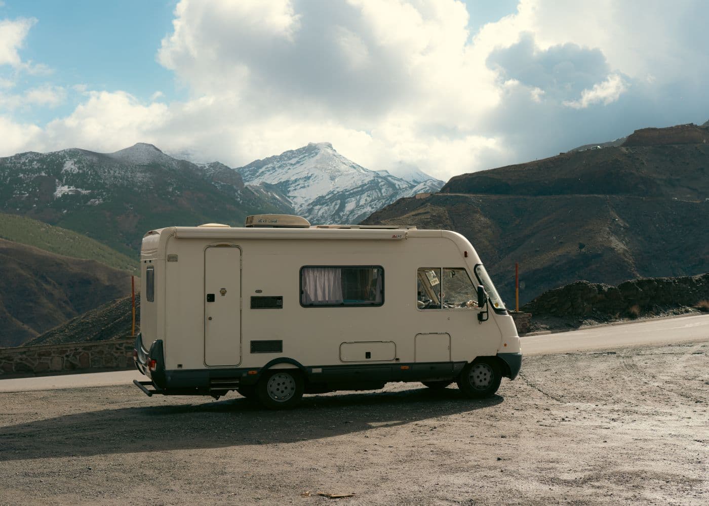 Campervan parked beside a dramatic mountain range