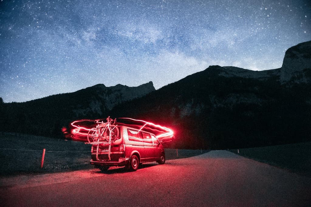 Campervan parked at night beneath mountains