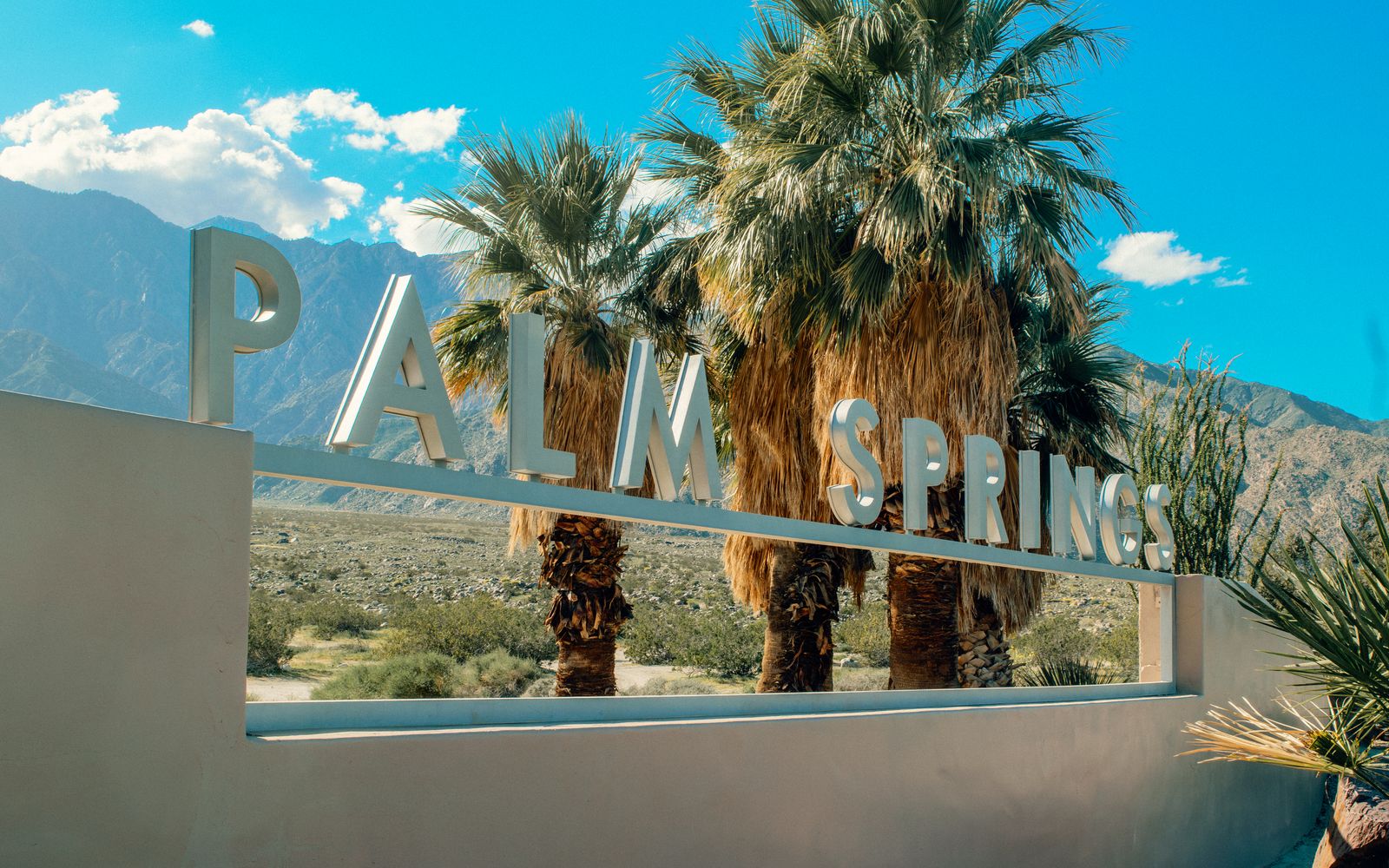 The Palm Springs sign with desert mountains, California
