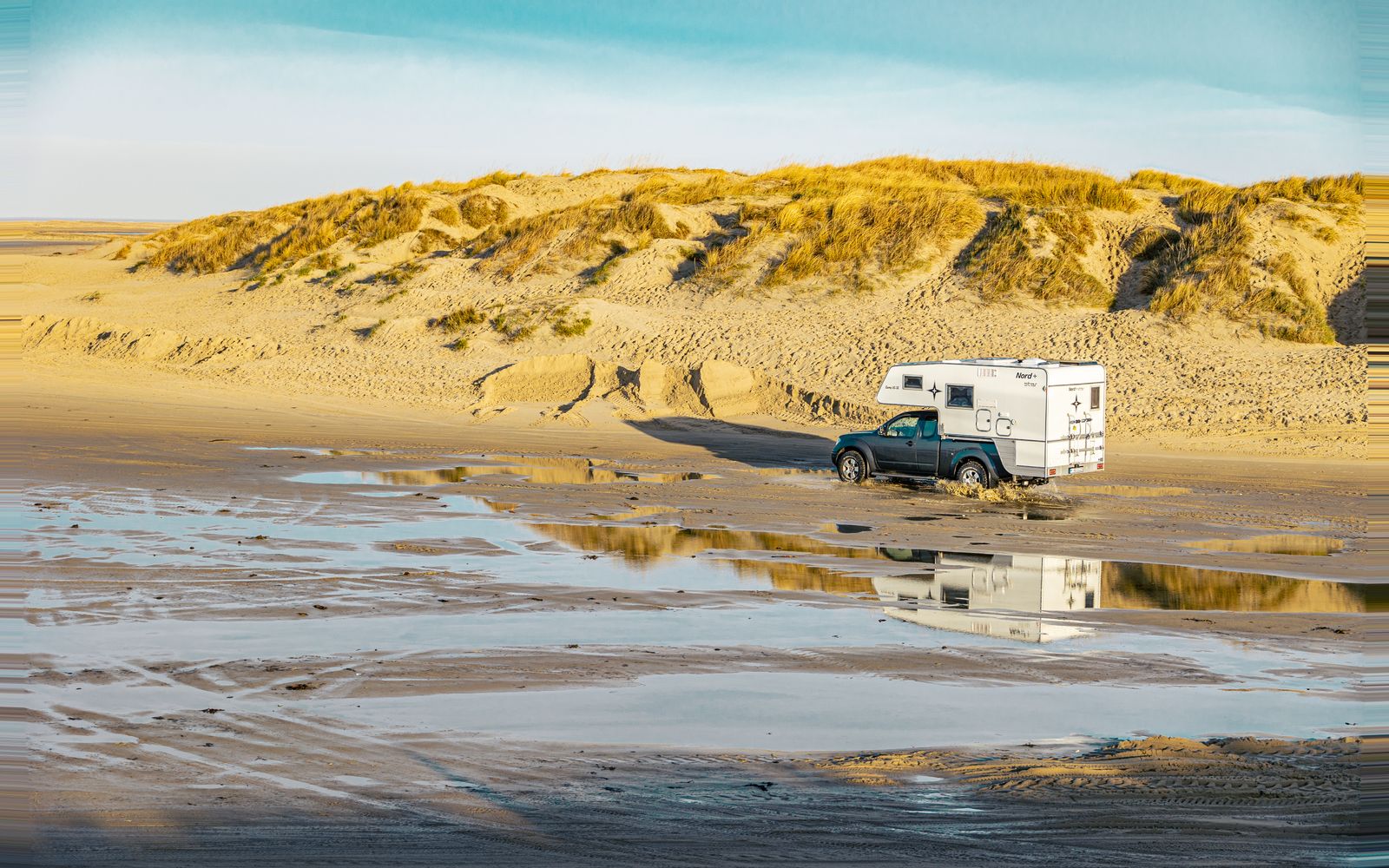 Campervan parked on a sandy beach by the sea — Dorset