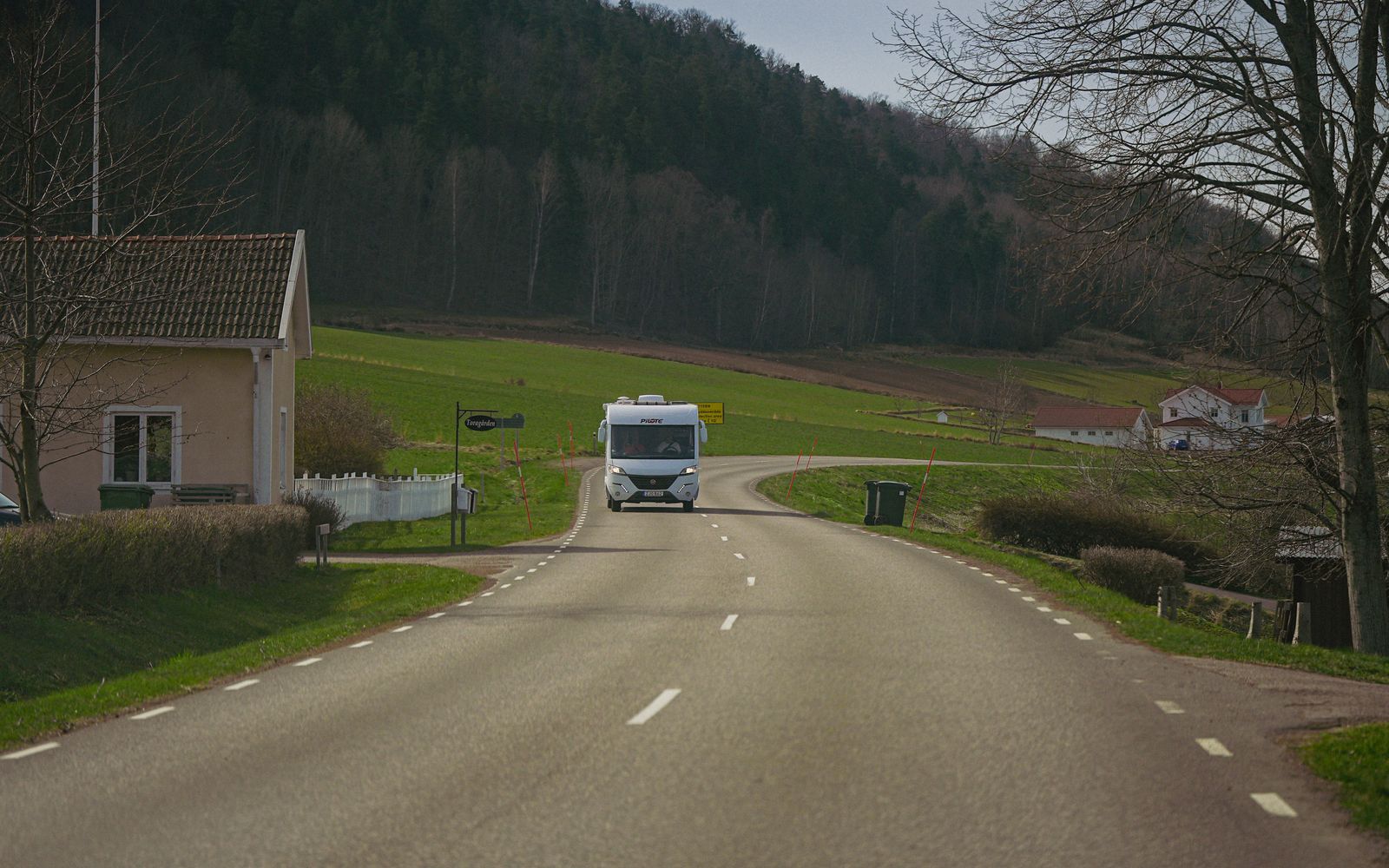 Campervan on a winding rural road through green hills — Cambridge